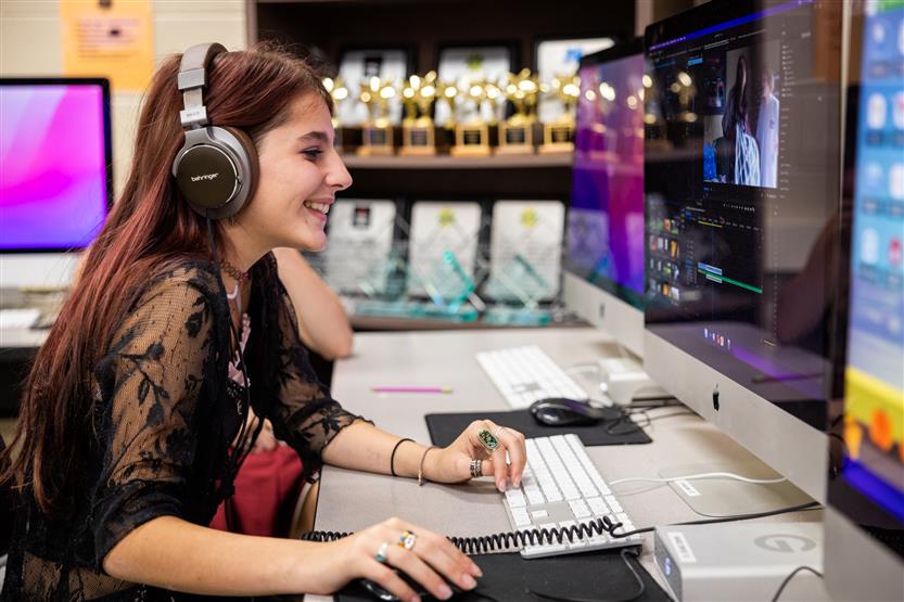 A student edits at a computer